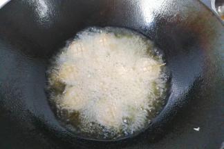 炸至微黄后翻面将另一面也炸好，炸好后捞出控油装盘；