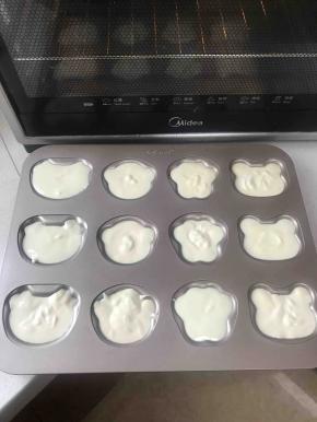 将装有原味蛋糕糊的裱花袋剪一个比可可味大一点点口，将蛋糕糊挤入模具里大概八九分满