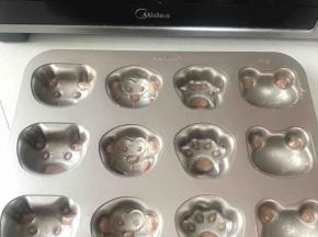 可可蛋糕糊的裱花袋剪一个小小的口，将模具的眼睛鼻子填充好可可蛋糕糊，放入预热好的烤箱烤两分钟定型