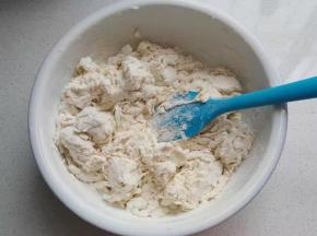 然后将牛奶液倒入面粉中，先搅拌成棉絮状；