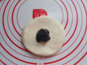 醒好后取一份小面团擀成圆饼，不要太薄，然后捏一份红糖馅放入中间；