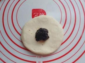 醒好后取一份小面团擀成圆饼，不要太薄，然后捏一份红糖馅放入中间；