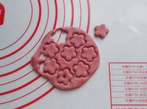 揉均匀的红面团先擀成薄面皮，然后用花朵小模具扣出几朵小花；