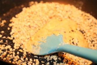 搅拌匀后倒入花生仁和芝麻关火搅拌匀（花生碎和芝麻要放在烤箱里100度保温，如果晾的果仁倒入，在你还没搅拌匀，会迅速凝固棉花糖，所以建议加热放入 ）