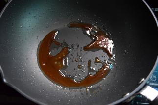留少许油，放入冰糖小火翻炒至深褐色