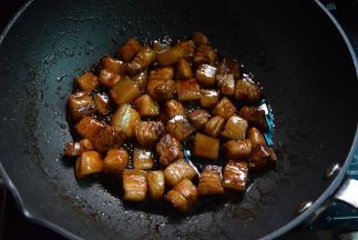 加入五花肉炒匀上色，再调入酱油和红烧汁炒匀