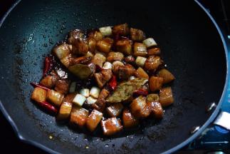 加盐、香叶、干辣椒、八角、桂皮和葱段炒出香味