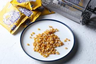 把玉米粒倒入盘中，涮一点点的色拉油至玉米粒表面。