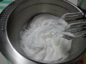 蛋清中分三次加入剩余的细砂糖，用电动打蛋器打至干性偏湿状态（如图）。