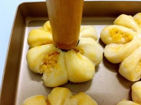 利用擀面杖沾上蛋液后再沾上黑芝麻后直接印在面包胚中间