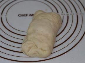 将二次发酵好的面团轻轻压一下，然后左右对折。