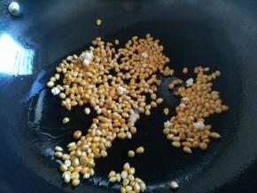 有一两个玉米粒爆开后盖上锅盖小火慢慢爆