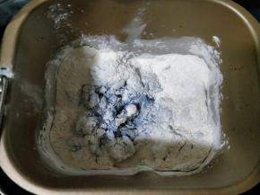 对角放盐和糖，再放入高粉和全麦粉，挖个洞放入酵母，启动揉面程序10分钟。