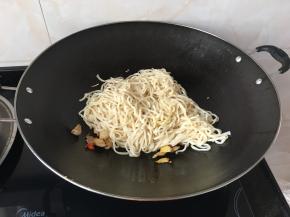 放入面条中火翻炒，要多翻炒以免粘锅