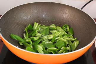 炒肉后的油留在锅中爆炒青椒，六成熟；