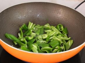 炒肉后的油留在锅中爆炒青椒，六成熟；