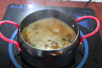 锅中放适量的水，把爆香的辣椒倒入，再放入花椒、八角、香叶熬煮出香味；