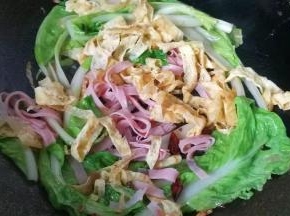 再放入火腿丝和鸡蛋皮，加少许盐翻炒均匀；