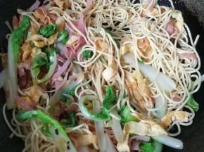 然后下入面条快速翻炒几下；