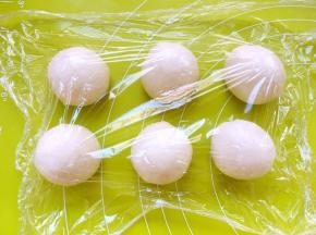 将面团用手掌滚圆，滚圆的时候力度要轻一些，滚至表层没有大气泡即可，盖保鲜膜松弛10分钟