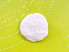 揭开保鲜膜，将面团翻个面，因为擀的一面比较光滑，我们用不光滑的一面来包裹椰蓉馅