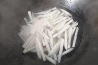 再烧开焯水，将萝卜条煮软煮熟后捞起沥干备用；