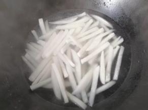 再烧开焯水，将萝卜条煮软煮熟后捞起沥干备用；