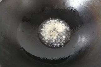 锅中入适量油，下蒜末煸出香味；