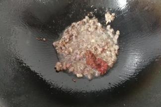 下入腌渍过的牛肉丁，炒至牛肉变色，再调入一勺豆瓣酱和黄豆酱炒均匀；
