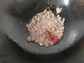 下入腌渍过的牛肉丁，炒至牛肉变色，再调入一勺豆瓣酱和黄豆酱炒均匀；