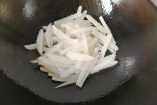 将锅洗净，调入适量油，下萝卜条炒几下；