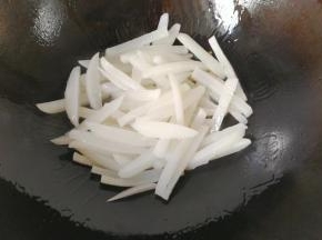 将锅洗净，调入适量油，下萝卜条炒几下；