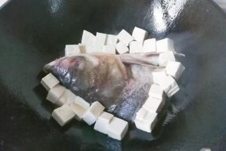 再把豆腐放在鱼头周围也煎一会儿；