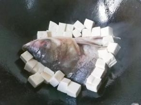 再把豆腐放在鱼头周围也煎一会儿；