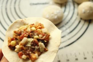 挖一勺包子馅放在皮上，根据自己的水平包成包子吧。