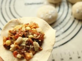 挖一勺包子馅放在皮上，根据自己的水平包成包子吧。