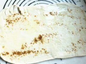 面团擀成长方形薄片，抹油和五香粉。