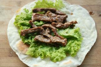 烙好的饼，铺一张生菜，再放上牛柳，卷起来就可以吃啦。