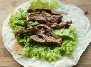 烙好的饼，铺一张生菜，再放上牛柳，卷起来就可以吃啦。