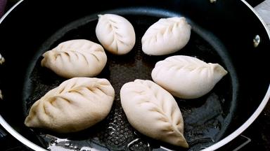 锅中刷一层，摆放包子，小火加热锅底，盖上锅盖醒发一会。