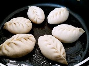 锅中刷一层，摆放包子，小火加热锅底，盖上锅盖醒发一会。