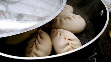 煎至底部成金黄色，倒入半碗清水，水量莫过包子底部，盖上锅盖小火煎片刻。