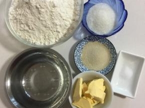 准备好主面团所需的材料:
面包粉500克，酵母6克，凉水320克，白糖60克，盐2克，黄油50克！