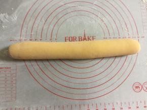 把面团放到揉面垫上排气，揉出气体，搓成长条。