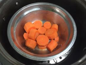 把胡萝卜去皮切段，放入合适的容器中，隔水蒸15分钟，把胡萝卜蒸熟。