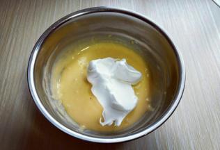 用硅胶刀取三分之的蛋白放入蛋黄糊容易中，翻拌均匀(切记手法，不要划算搅拌，以免消泡) 从底下往上翻拌，手法要轻轻的。 再取三分之一的蛋白霜加入蛋黄糊中，继续上面的手法，翻拌直至看不到蛋白霜。