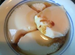 挖出凝结的豆腐脑，加入适量生抽和香油