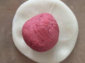 将（之前分好了四份的油皮）每份油皮平均分成3份，一共是12份揉圆。

接下来，取一份油皮，按扁，包入一份油酥。