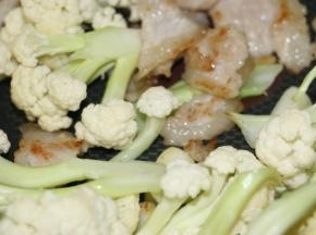 炒至花菜梗有点变色下五花肉继续翻炒