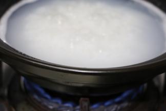 锅里放入适量的水，水烧开后下米，大火烧开转中小火熬煮